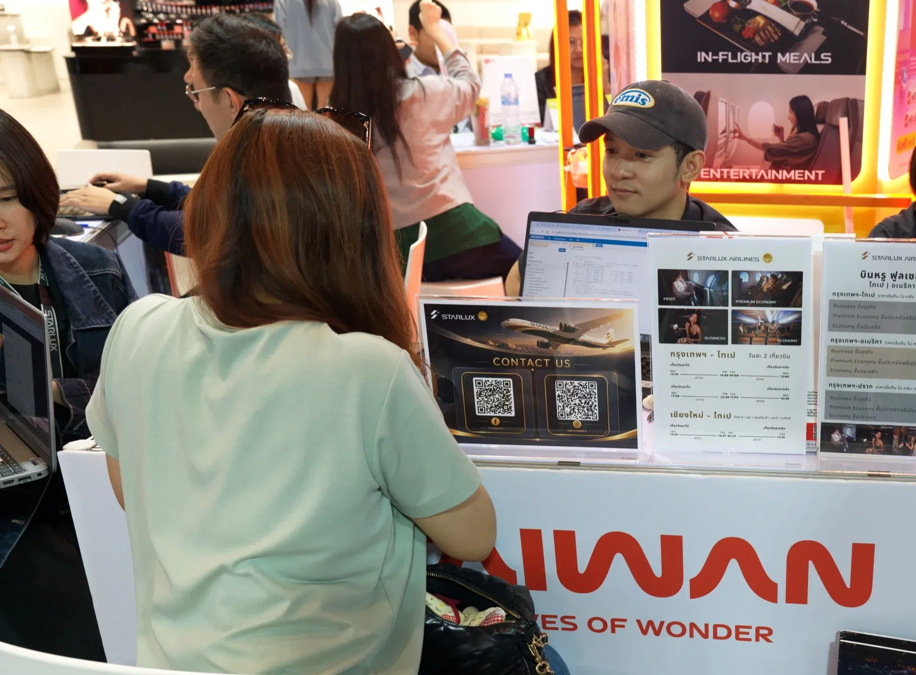 参观者在星宇航空展台咨询,柜台上摆有航线与舱等资料